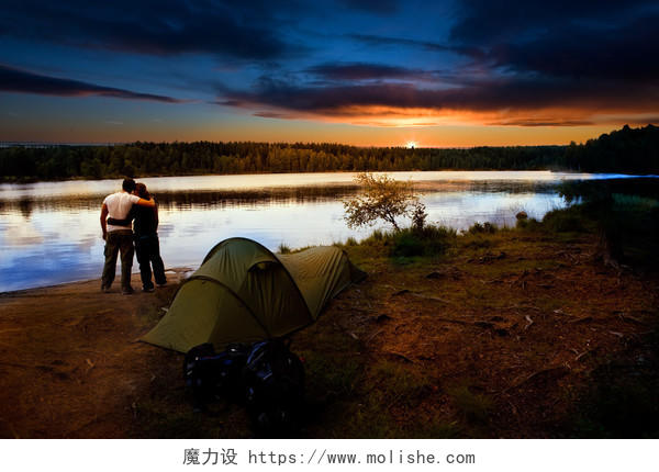 落日湖泊草地帐篷露营者一对情侣背影幸福情侣户外旅游图片
